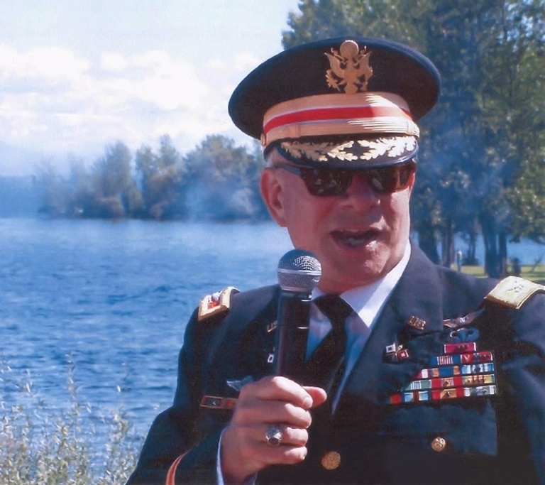 A man in military uniform holding a microphone.