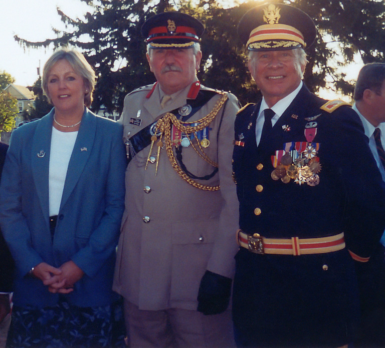 A man in uniform standing next to two women.