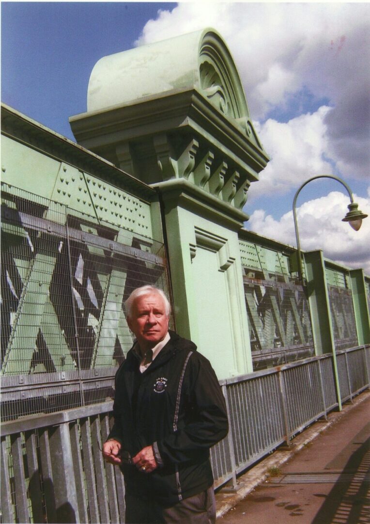 A man standing in front of a green building.